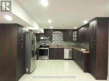Brampton (Toronto Gore Rural Estate) apartment for rent - A kitchen with dark wood cabinets and stainless steel appliances.