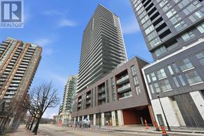 Burlington (Brant) condo for rent - A modern building with a curved glass facade stands in front of other buildings.