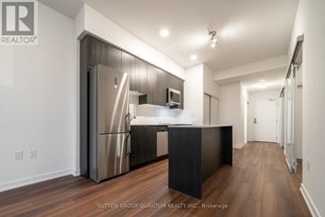 Toronto (Briar Hill-Belgravia) condo for rent - A modern kitchen with a refrigerator, microwave, and stove top oven.