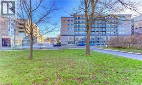 Waterloo condo for rent - A grassy area with trees and a building in the background.