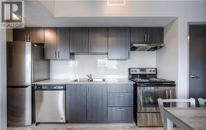 Waterloo condo for rent - A modern kitchen with stainless steel appliances and grey cabinets.