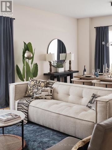 Ottawa condo for rent - A living room with a white sofa and a round mirror on the wall.