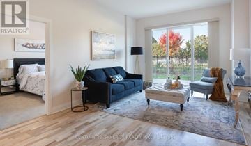 Ottawa condo for rent - A living room with a black couch and a painting on the wall.