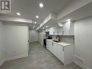 Brampton (Fletcher's Meadow) apartment for rent - A modern kitchen with white cabinets and a wooden floor.