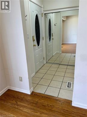 Hamilton apartment for rent - A white door with a round window is in a hallway.