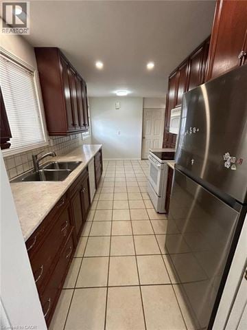 Hamilton apartment for rent - A kitchen with a stainless steel refrigerator and brown cabinets.
