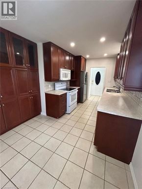 Hamilton apartment for rent - A kitchen with brown cabinets and a white fridge.
