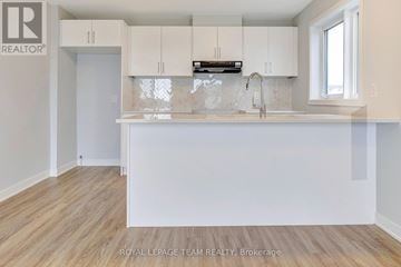 Ottawa townhouse for rent - A kitchen with white cabinets and a wooden floor.