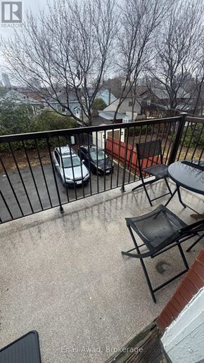 Ottawa triplex for rent - A balcony with a black chair and a table.