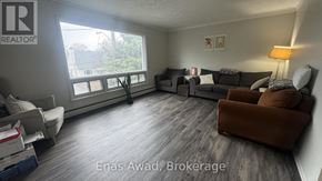 Ottawa triplex for rent - A living room with a couch, chairs, and a window.