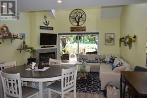 Ramara (Brechin) townhouse for rent - A living room with a fireplace and a dining table.