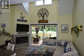 Ramara (Brechin) townhouse for rent - A living room with a fireplace and a television.