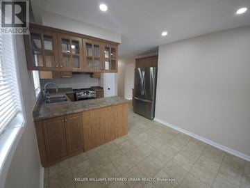 Toronto (Glenfield-Jane Heights) apartment for rent - A kitchen with wooden cabinets and a refrigerator.