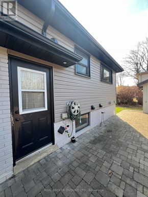 Burlington (Appleby) apartment for rent - A house with a black door and a window with a white curtain.