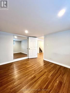 Burlington (Appleby) apartment for rent - A room with wooden floors and white walls, with a doorway leading to another room.