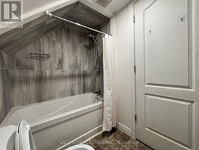Windsor apartment for rent - A bathroom with a bathtub and a shower curtain.