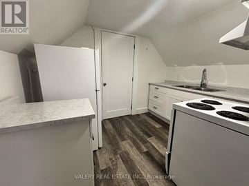 Windsor apartment for rent - A kitchen with a white fridge, sink, and stove top oven.