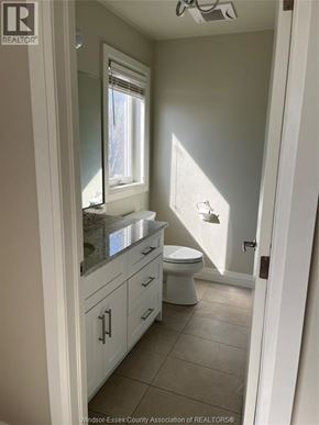 Windsor apartment for rent - A white bathroom with a toilet, sink and mirror.