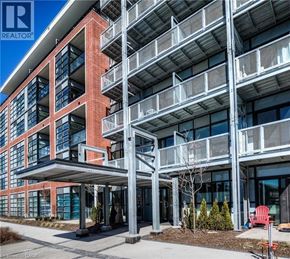 Kitchener condo for rent - A modern building with a red brick facade and a balcony on the second floor.