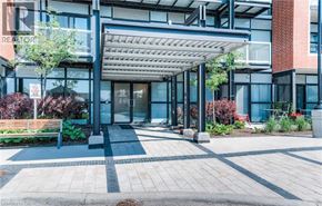 Kitchener condo for rent - A modern building entrance with a glass door and a canopy over the steps.