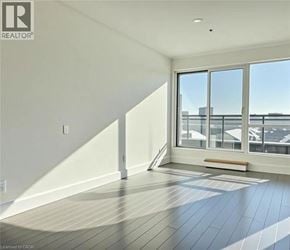 Kitchener condo for rent - A room with a slanted ceiling and a window overlooking a parking lot.