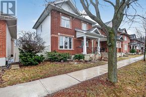 Ottawa apartment for rent - A red brick house with a white trim and a tree in front.