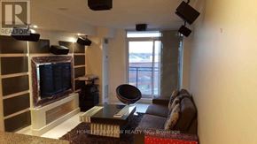 Toronto (York University Heights) condo for rent - A living room with a flat screen TV and a black leather couch.