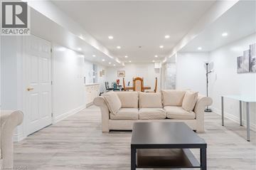 Ancaster apartment for rent - A modern living room with a large beige sofa and a wooden coffee table.