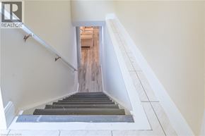 Ancaster apartment for rent - A staircase with a white railing and wooden steps leading to a doorway.