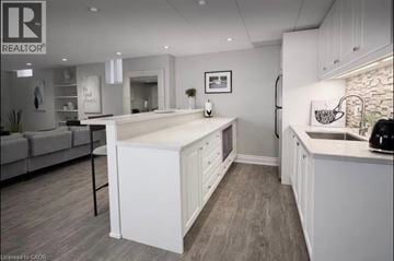 Waterdown apartment for rent - A modern kitchen with white cabinets and a large island.