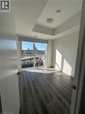 Kitchener condo for rent - A room with a view of a body of water through a sliding glass door.