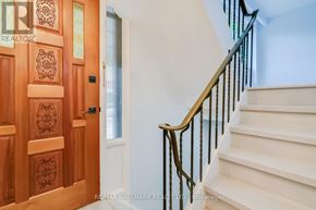 Toronto (East End-Danforth) apartment for rent - A staircase with a wooden banister and a door with a wooden panel and carvings.