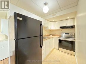 Richmond Hill (Westbrook) apartment for rent - A black fridge in a kitchen with white cabinets.