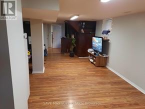 Barrie (Wellington) apartment for rent - A living room with a TV and a person standing in the background.