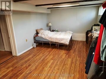 Barrie (Wellington) apartment for rent - A bedroom with a bed and a wooden floor.