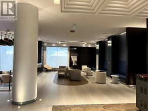 Oakville (Jm Joshua Meadows) condo for rent - A modern office lobby with a large column and a view of the sky through the windows.