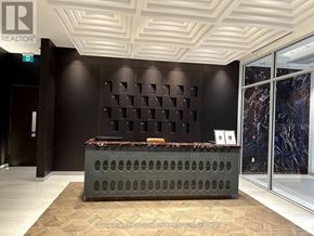 Oakville (Jm Joshua Meadows) condo for rent - A reception area with a dark brown wall and a grey reception desk.