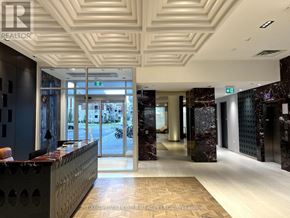 Oakville (Jm Joshua Meadows) condo for rent - The image shows a well-lit, modern office lobby with a reception desk and a marble floor.