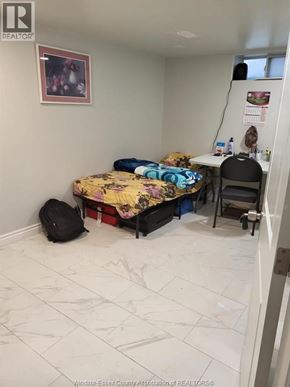 Windsor apartment for rent - A bedroom with a bed, desk, chair, and a backpack.