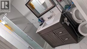 Windsor apartment for rent - A bathroom with a toilet, sink, and mirror.
