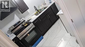 Windsor apartment for rent - A kitchen with black cabinets and a white countertop.