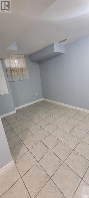 Toronto (O'connor-Parkview) townhouse for rent - A room with a tiled floor and a window with curtains.