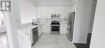 Brampton (Northwest Brampton) townhouse for rent - A kitchen with white cabinets and marble countertops.