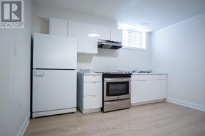 Toronto (Englemount-Lawrence) apartment for rent - A white kitchen with a fridge, oven, and microwave.