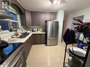 Toronto (Malvern) apartment for rent - A kitchen with a stove top oven, sink, and refrigerator.