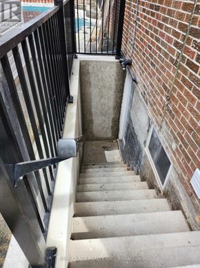 Toronto (Centennial Scarborough) apartment for rent - A stairway with a black railing and a brick wall.