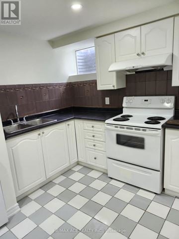 Toronto (Centennial Scarborough) apartment for rent - A white stove and oven in a kitchen with white cabinets and a checkered floor.