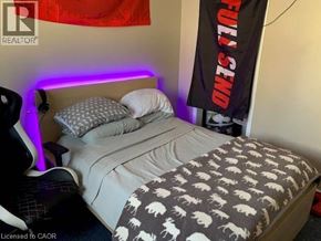 Waterloo apartment for rent - A bed with a grey and white patterned blanket and pillows.