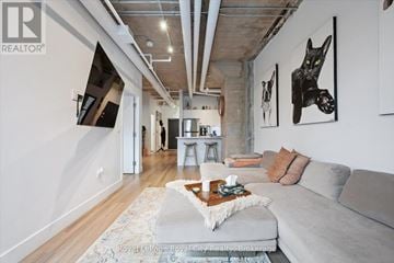 Guelph (St. Patrick's Ward) condo for rent - A living room with a grey couch and a coffee table in front of it.