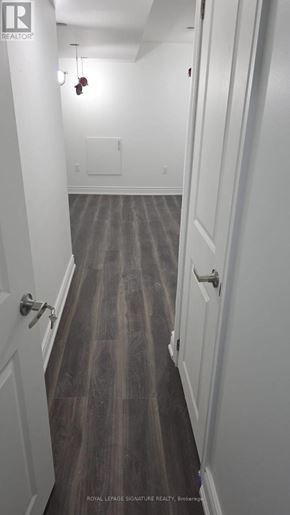 Clarington (Bowmanville) apartment for rent - A long hallway with white walls and wood floors.